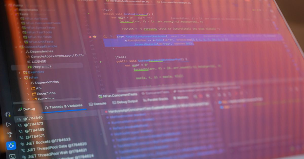 Focused view of a computer screen displaying programming code with visible reflections.